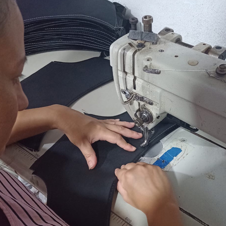 Woman sewing upholstery in the local workshop